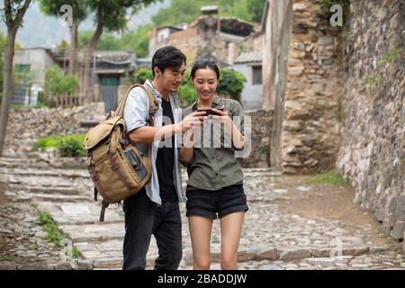 Young Chinese couple using smartphone in village Stock Photo