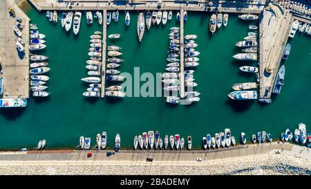 Aerial bird's eye view of Latchi port, Akamas peninsula, Polis Chrysochous, Paphos, Cyprus. The Latsi harbour with boats and yachts aligned, fish rest Stock Photo