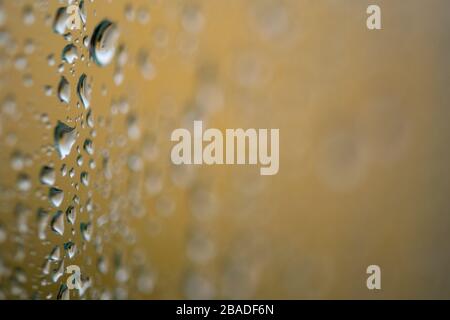 rain water droplets on a window with a golden background Stock Photo