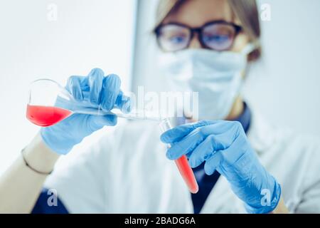 Young scientist looking through a microscope in a laboratory. Young scientist doing some research. Stock Photo