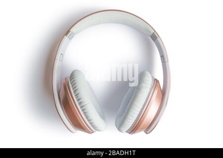 Rose gold wireless headphones isolated on a white background. Stock Photo