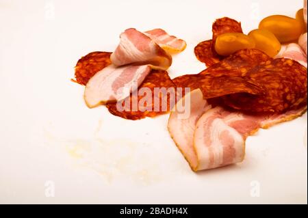 Slices of bacon and sausage and tomatoes on a white background. Close up Stock Photo