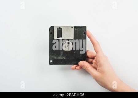 partial view of man holding black diskette on white background Stock Photo