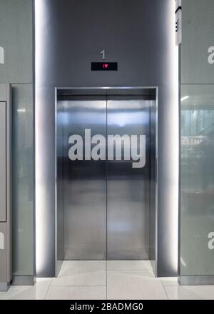 Closed elevator doors glossy illuminated in lobby hotel Stock Photo