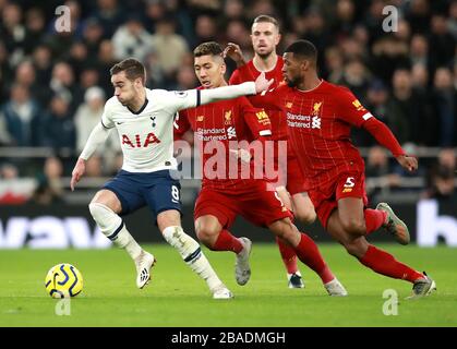 Tottenham Hotspur's Harry Winks (left) under pressure from Liverpool's Roberto Firmino and Georginio Wijnaldum (right) Stock Photo