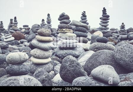 Stone stacks on a beach, color toning applied, selective focus. Stock Photo