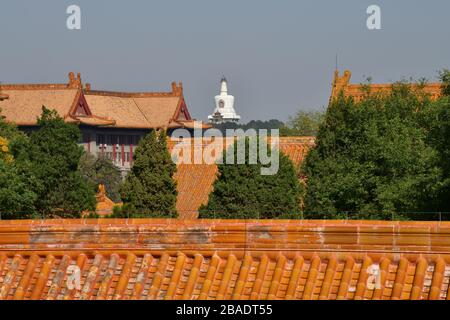 Ancient palaces of the Forbidden City in Beijing China with the temple of the White Dagoba (Baita Si) in th back Stock Photo