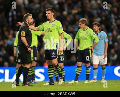 Aston Villa's Ciaran Clark (6) appeals to match referee Jon Moss (left) after Manchester City are awarded a second penalty Stock Photo