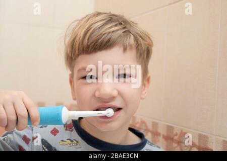 Little boy brushes his teeth with an electric toothbrush. Health care concept Stock Photo