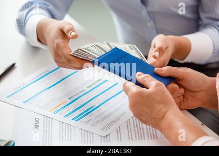 Travel agent at office taking money and passport from senior client close-up Stock Photo