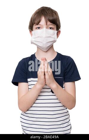 Little boy with face mask praying, looking up, isolated on white background Stock Photo