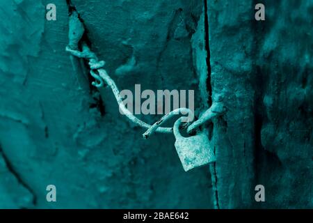 Old rusty lock with wire. Moroccan, mint-green, wooden door detail. Background image, Concept for abandoned old houses.