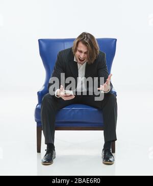 The serious handsome men in black suit on a white background, brutal man with long curly hairs, white shirt, business man, very stylish, blue leather Stock Photo