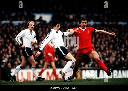 Tottenham Hotspur's John Pratt (c) tries to clear from Liverpool's Graeme Souness (r), watched by teammate Terry Yorath (l) Stock Photo