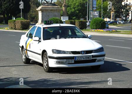 White Spanish Taxi in the city centre, Seville, Spain - April 08, 2009 Stock Photo