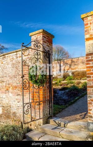 Decorative Christmas wreaths on a gate in the walled garden at Stourhead House, Wiltshire, England, UK Stock Photo