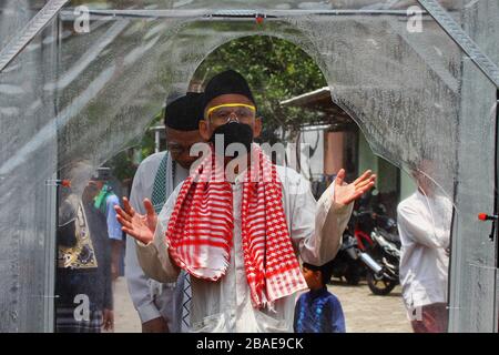 Yogyakarta, Indonesia. 27th Mar, 2020. People entered a disinfectant chambers to prevent the spread Coronavirus (Covid-19) while going to worship at the Ploso Kuning Mosque in Yogyakarta, Indonesia, Friday, March 27, 2020. Based on data Indonesian government reports, Indonesia has confirmed 1,046 cases of coronavirus and 87 cases of death. (Photo by Devi Rahman/INA Photo Agency/Sipa USA) Credit: Sipa USA/Alamy Live News Stock Photo