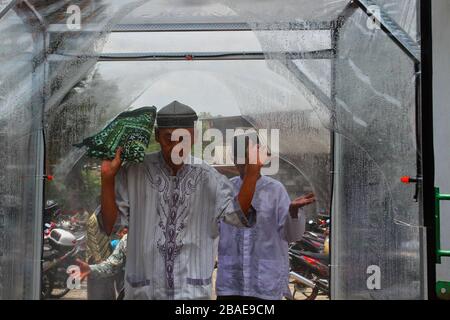Yogyakarta, Indonesia. 27th Mar, 2020. People entered a disinfectant chambers to prevent the spread Coronavirus (Covid-19) while going to worship at the Ploso Kuning Mosque in Yogyakarta, Indonesia, Friday, March 27, 2020. Based on data Indonesian government reports, Indonesia has confirmed 1,046 cases of coronavirus and 87 cases of death. (Photo by Devi Rahman/INA Photo Agency/Sipa USA) Credit: Sipa USA/Alamy Live News Stock Photo