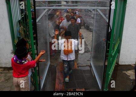 Yogyakarta, Indonesia. 27th Mar, 2020. People entered a disinfectant chambers to prevent the spread Coronavirus (Covid-19) while going to worship at the Ploso Kuning Mosque in Yogyakarta, Indonesia, Friday, March 27, 2020. Based on data Indonesian government reports, Indonesia has confirmed 1,046 cases of coronavirus and 87 cases of death. (Photo by Devi Rahman/INA Photo Agency/Sipa USA) Credit: Sipa USA/Alamy Live News Stock Photo