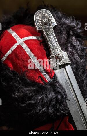 Beautiful example of caucasian dagger with red  Kuban cossack papakha. 19th century (Time of Russian-Caucasian wars (1816-1864)). Russia Stock Photo