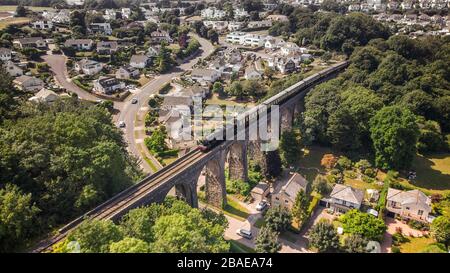 Aerial drone view of the Dartmouth Steam railway locomotive passing over the broadsands viaduct Stock Photo