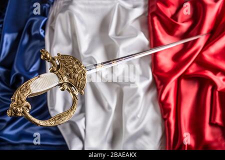 French officer court sword (shortsword) an silk French flag background.The 19th century. France.