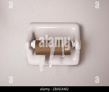 Empty toilet paper roll on white wall in bathroom Stock Photo