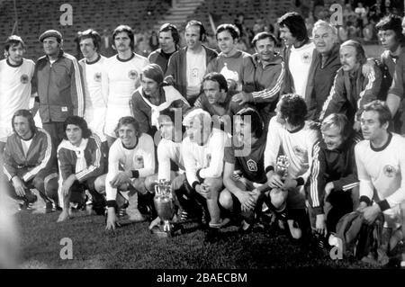 Czechoslovakia players, the majority wearing West Germany shirts after swapping with their defeated opponents, pose with the trophy after the match Stock Photo