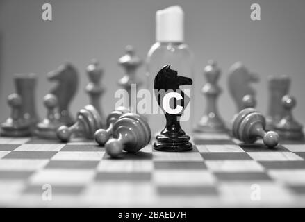 Coronavirus concept image chess pieces and hand sanitizer on chessboard illustrating global struggle against novel covid-19 outbreak. Stock Photo