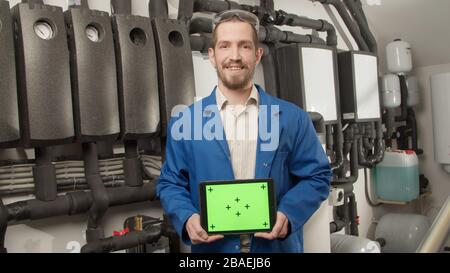 Young engineer smiling at camera with tablet Stock Photo