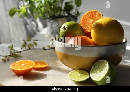 Still life with orange fruit and mint  on white marble top and canvas. Stock Photo