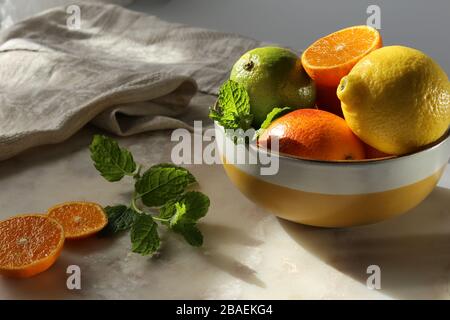 Still life with orange fruit and mint  on white marble top and canvas. Stock Photo