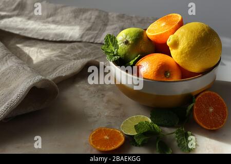 Still life with orange fruit and mint  on white marble top and canvas. Stock Photo