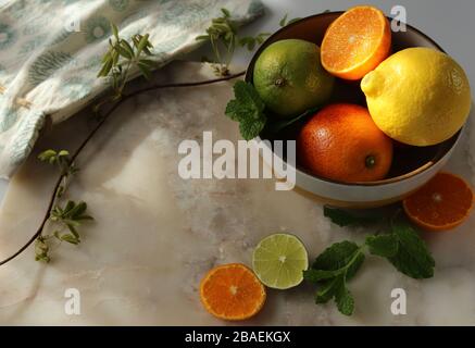 Still life with orange fruit and mint  on white marble top and canvas. Stock Photo