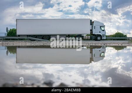 Truck with refrigerated semi-trailer for the transport of perishable food circulating on the highway Stock Photo