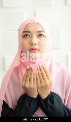 Muslim women pray for Allah in the mosque to quickly escape the crisis of the Coronavirus epidemic. Stock Photo