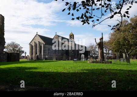 The Parish Church of Saint Mary the Virgin and statue of St Aidan, Lindisfarne Priory, Holy Island; Northumberland; England Stock Photo