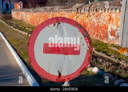 Old road sign forbidding passage, against a brick wall. Stock Photo