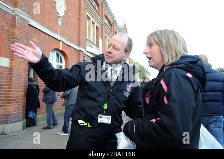 Fulham stewards help fans around the stadium on match day Stock Photo