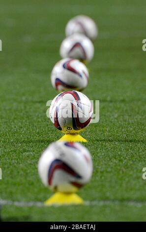 Detail of official Crawley Town Mitre footballs sat on training cones on the pitch before the game Stock Photo