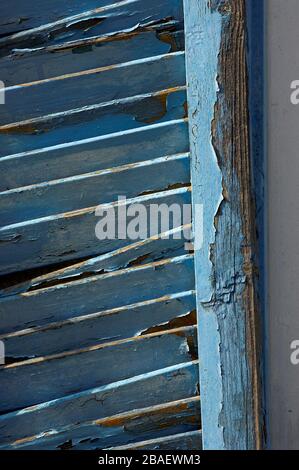 Old window shutters on a house in Cyprus, with blue paint peeling off. Stock Photo