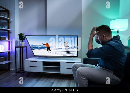 Frustrated Man Looking At Falling Television. Liability Insurance Stock Photo