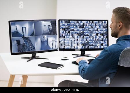 Man In Control Room Monitoring CCTV Footage Stock Photo