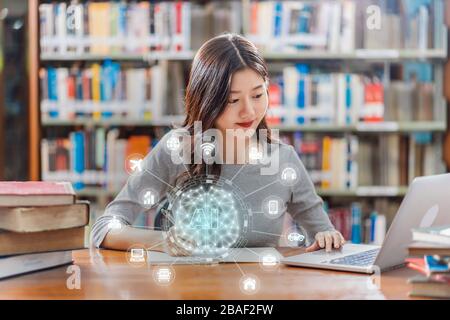 Polygonal brain shape of an artificial intelligence with various icon of smart city Internet of Things Technology over Asian young Student using techn Stock Photo