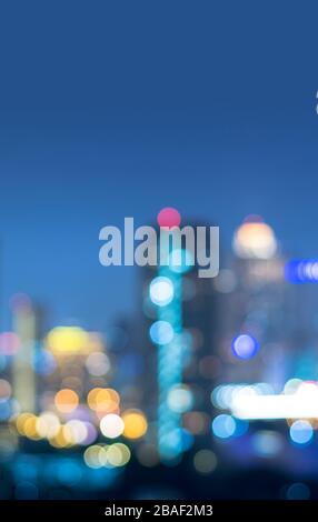 Vertical cover of blurred bokeh cityscape at twilight time, city background, aerial view angle from rooftop ob building, defocused city in downtown,gr Stock Photo