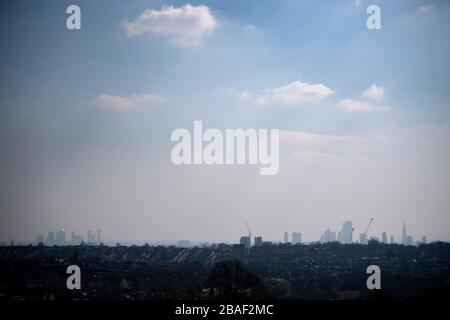 Canary Wharf and the City of London skyline viewed through the haze from Alexandra Palace, north London. Stock Photo