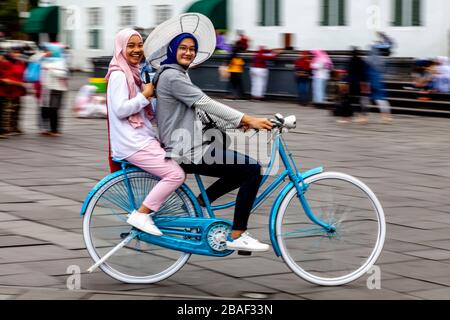 Young Indonesian Women Cycling In Taman Fatahillah Square, Jakarta, Indonesia. Stock Photo