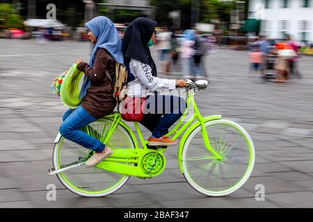 Young Indonesian Women Cycling In Taman Fatahillah Square, Jakarta, Indonesia. Stock Photo