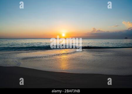 Young women sitting on the beach of Anse Petit in Mahe Island Seychelles Stock Photo