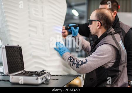 Technicians use UV lamp light for curing resin 3d print printed on modern 3d printer machine Stock Photo